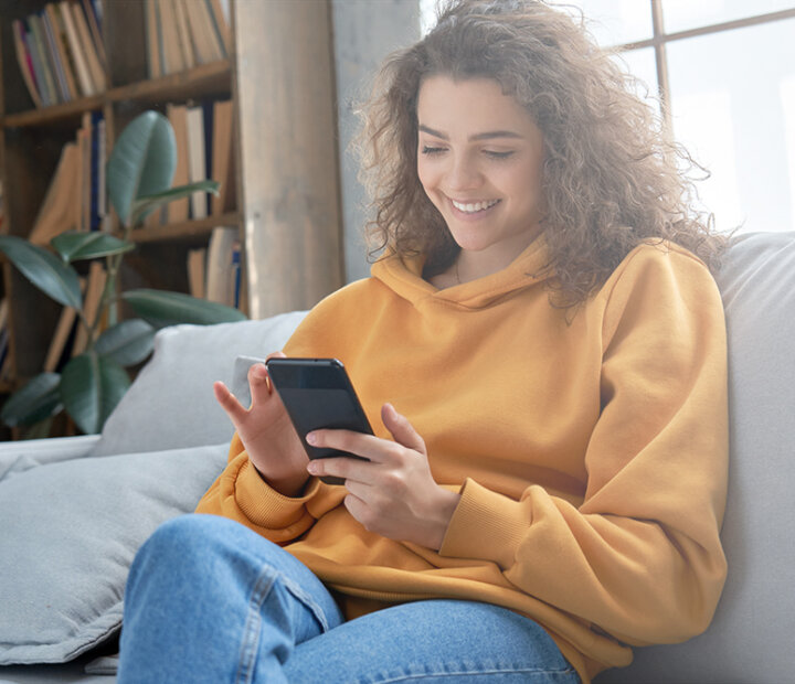 KYC-women yellow jumper phone-header-1000x667