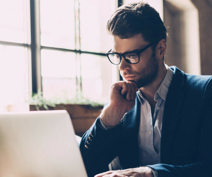 partner why callsign ensembling platform account creation & registration psd2 behavioral-man in glasses looking at laptop-content-720x600